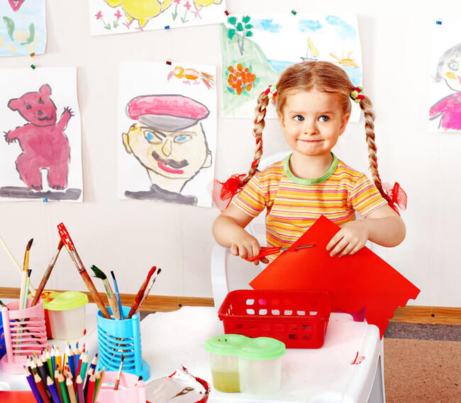 A young child is painting herself with bright colors.