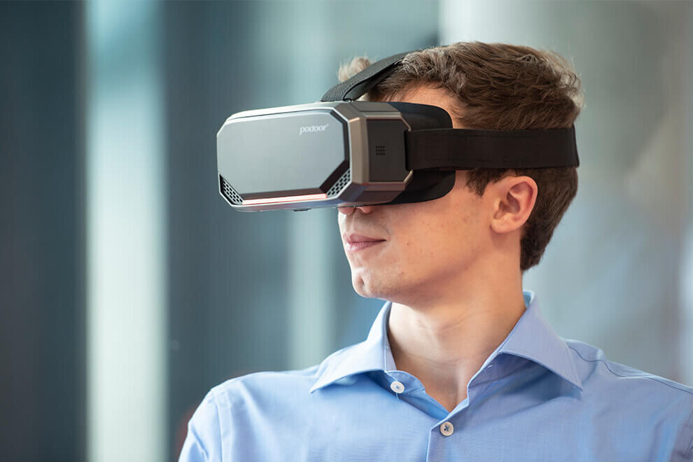 A young man is wearing a virtual reality headset.