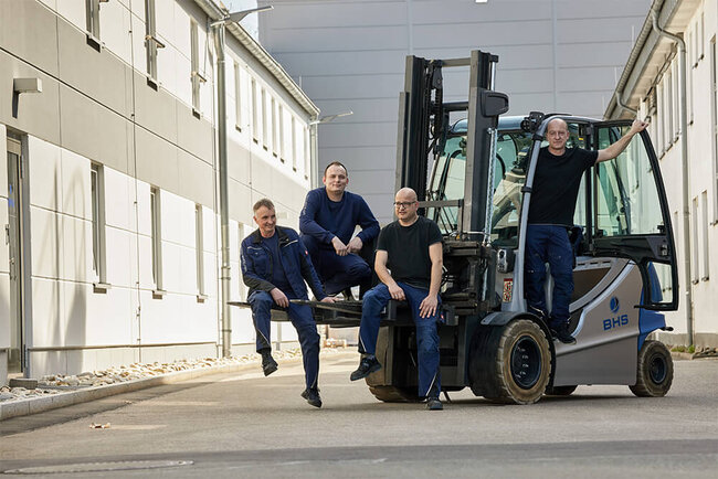 Markus Stemmer and three other men from his team on a forklift truck.