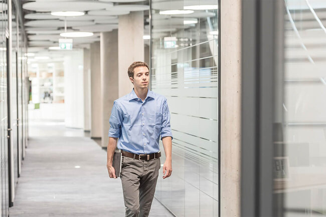 A young man is walking through the company halls.
